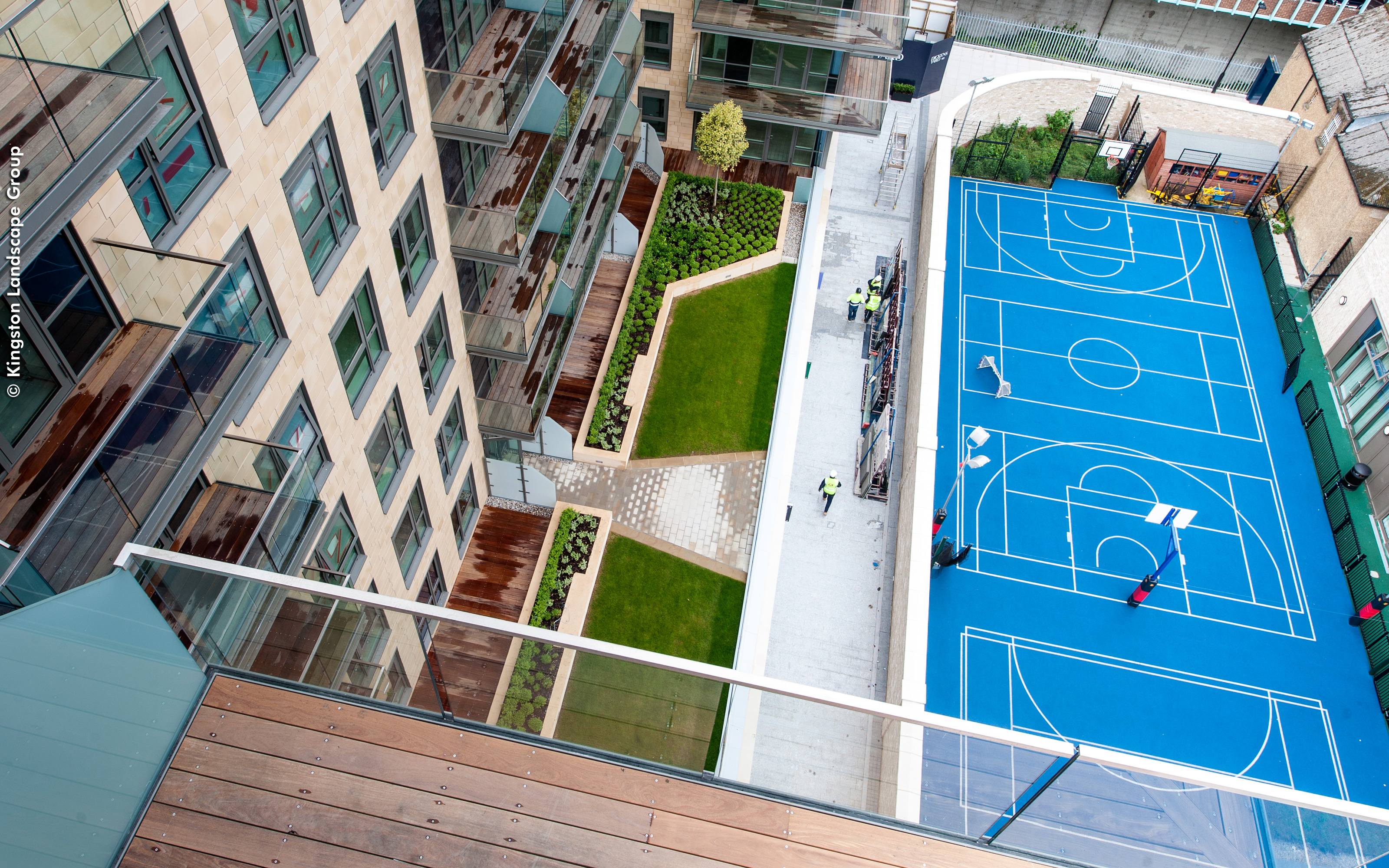 The courtyard also provides an outdoor basketball court. Bird's eye view into a green courtyard and a basketball court